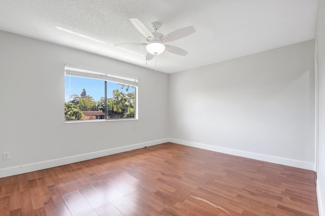 unfurnished room with a ceiling fan, wood finished floors, and baseboards