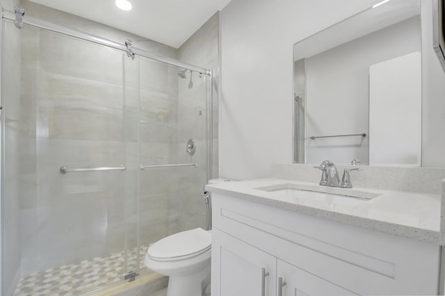bathroom featuring toilet, a stall shower, recessed lighting, and vanity