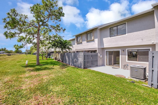 exterior space with a patio, central air condition unit, a yard, stucco siding, and fence