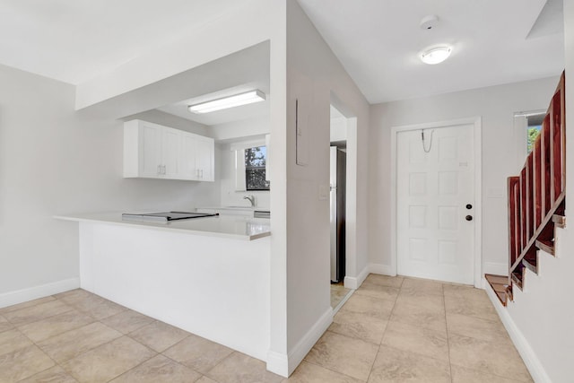 entryway with light tile patterned floors, plenty of natural light, stairway, and baseboards