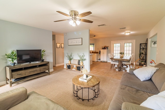 living room featuring baseboards, visible vents, ceiling fan, and tile patterned flooring