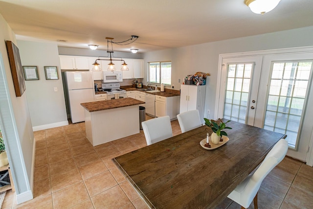 dining room featuring light tile patterned flooring, french doors, and baseboards