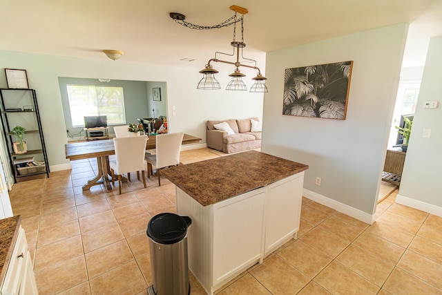 kitchen with white cabinets, pendant lighting, a wealth of natural light, and light tile patterned flooring