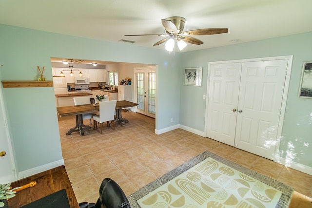 foyer entrance with light tile patterned flooring, a ceiling fan, visible vents, baseboards, and french doors