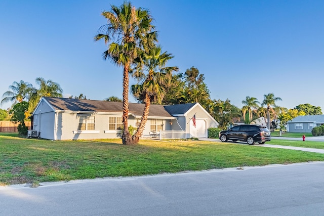 view of front of house featuring a garage, fence, a front yard, and concrete driveway