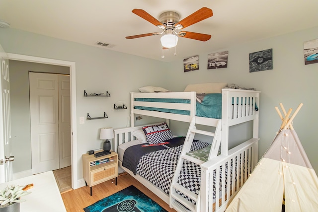 bedroom with visible vents, ceiling fan, wood finished floors, and baseboards