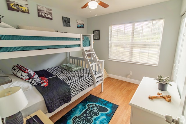 bedroom featuring ceiling fan, light wood-style flooring, and baseboards