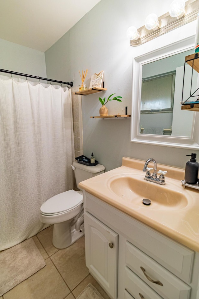 bathroom featuring toilet, vanity, a shower with curtain, and tile patterned flooring