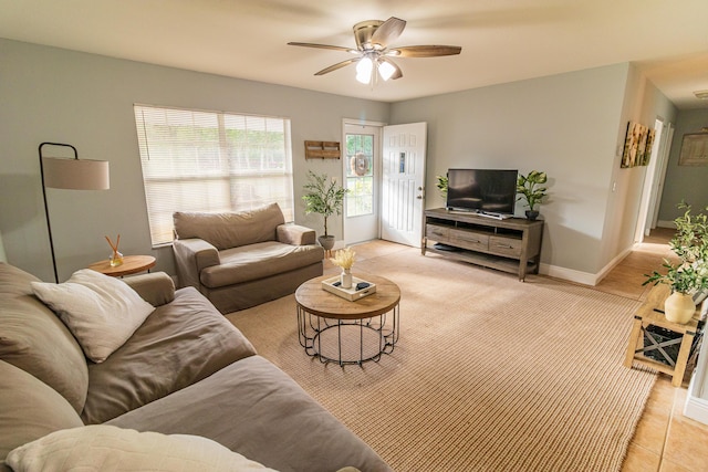 living area with a ceiling fan and baseboards