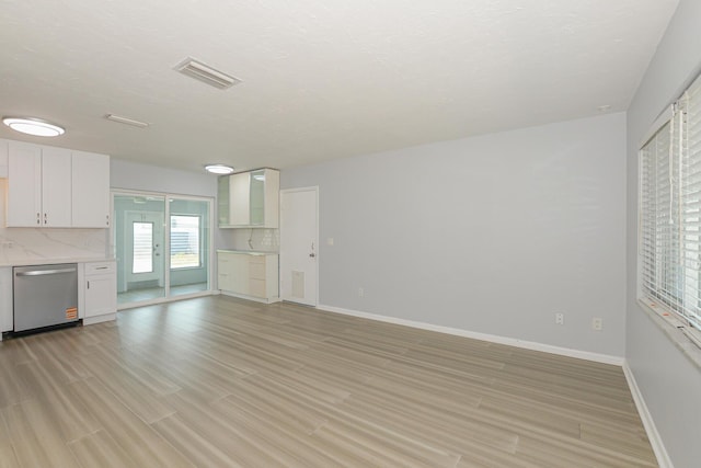712 NE Camino St, Port Saint Lucie, FL 34952 - unfurnished living room with light wood-style floors, baseboards, and visible vents