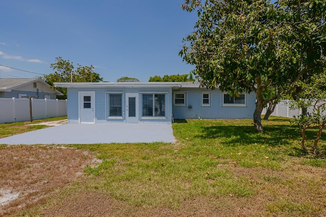 712 NE Camino St, Port Saint Lucie, FL 34952 - back of property featuring a patio area, fence, and a yard