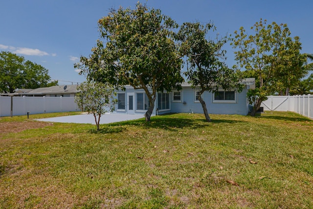 712 NE Camino St, Port Saint Lucie, FL 34952 - back of house featuring a lawn, a patio, stucco siding, and a fenced backyard