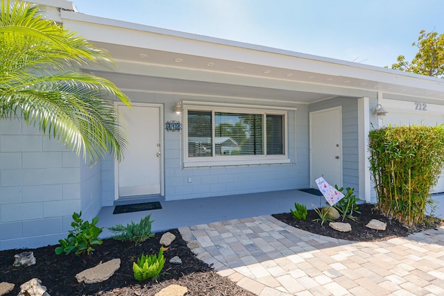 712 NE Camino St, Port Saint Lucie, FL 34952 - doorway to property with concrete block siding and a porch