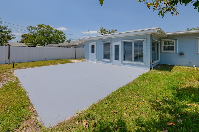712 NE Camino St, Port Saint Lucie, FL 34952 - rear view of house featuring a patio, a fenced backyard, concrete block siding, and a yard