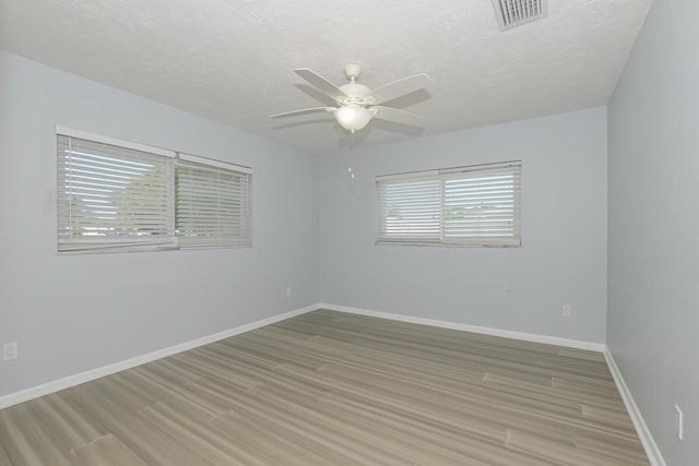 712 NE Camino St, Port Saint Lucie, FL 34952 - spare room featuring light wood-style floors, baseboards, ceiling fan, and visible vents