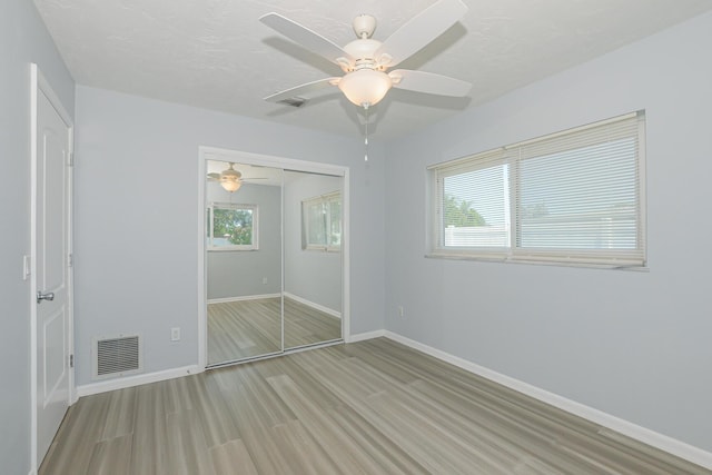 712 NE Camino St, Port Saint Lucie, FL 34952 - unfurnished bedroom with baseboards, visible vents, wood finished floors, and a closet