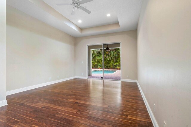 6616 Cobia Cir, Boynton Beach, FL 33437 - unfurnished room with wood finished floors, ceiling fan, baseboards, a tray ceiling, and recessed lighting