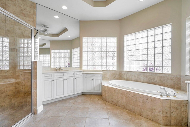 bathroom with ceiling fan, a shower stall, a garden tub, and vanity
