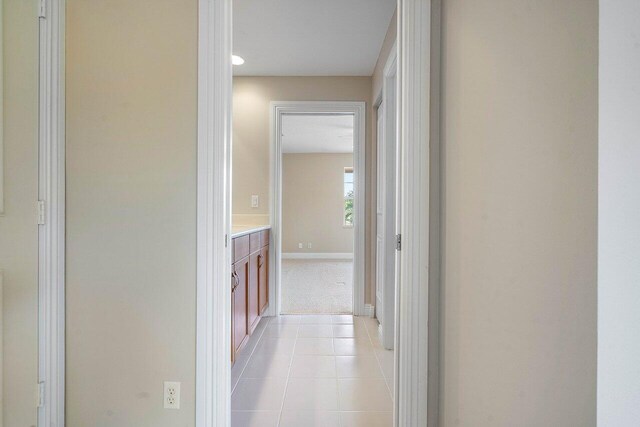 6616 Cobia Cir, Boynton Beach, FL 33437 - hallway featuring baseboards, light tile patterned floors, and light carpet