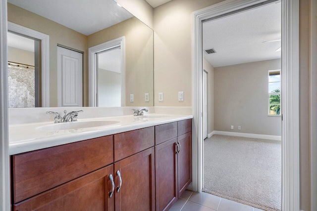 full bathroom featuring double vanity, a sink, tile patterned floors, and visible vents
