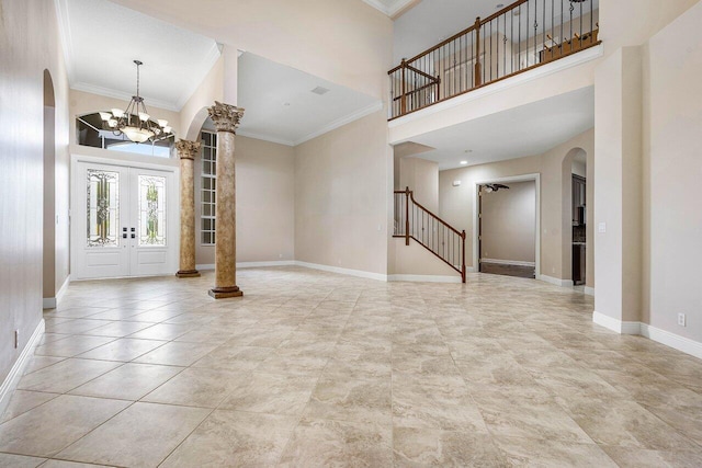 entrance foyer featuring ornate columns, a towering ceiling, and arched walkways