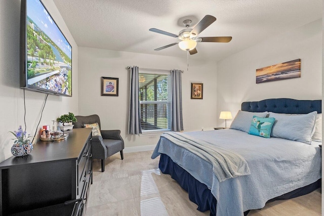 bedroom featuring baseboards, ceiling fan, and a textured ceiling
