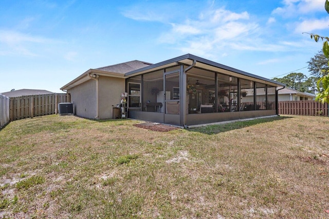 back of house featuring central AC, a fenced backyard, a sunroom, and a lawn