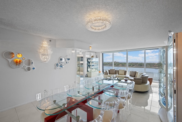525 S Flagler Dr Unit 16A, West Palm Beach, FL 33401 - dining area with a water view, a textured ceiling, a notable chandelier, and light tile patterned floors