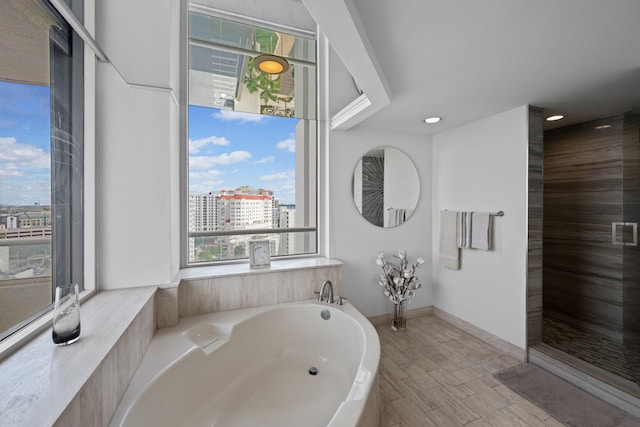525 S Flagler Dr Unit 16A, West Palm Beach, FL 33401 - full bathroom featuring a garden tub, wood finished floors, a city view, recessed lighting, and tiled shower