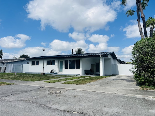 4730 W 8th Pl, Hialeah, FL 33012 - ranch-style house with driveway, metal roof, fence, a front lawn, and stucco siding