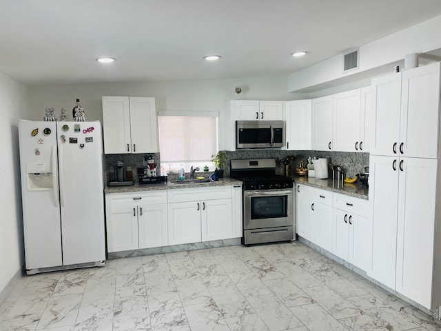 4730 W 8th Pl, Hialeah, FL 33012 - kitchen with marble finish floor, dark stone counters, white cabinets, backsplash, and stainless steel appliances