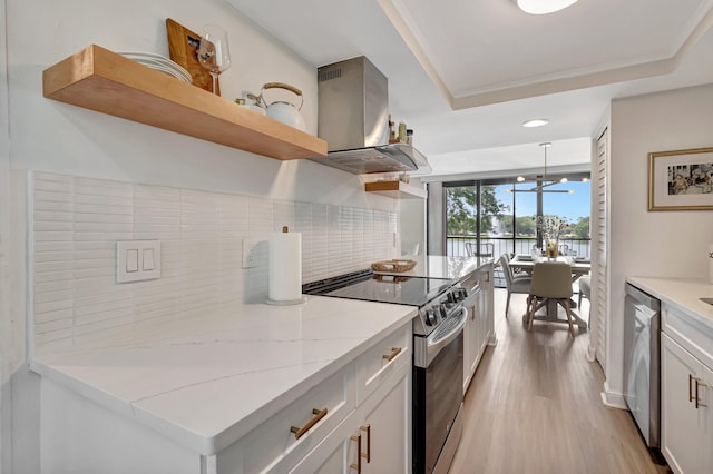 kitchen featuring island range hood, decorative backsplash, open shelves, appliances with stainless steel finishes, and a tray ceiling
