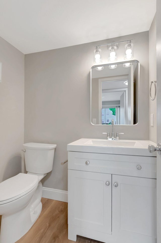 296 Fanshaw H, Boca Raton, FL 33434 - half bathroom featuring wood finished floors, toilet, vanity, and baseboards
