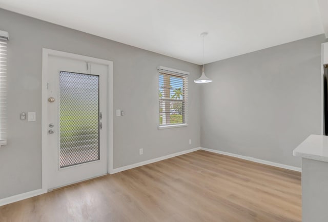 296 Fanshaw H, Boca Raton, FL 33434 - unfurnished dining area with light wood-type flooring and baseboards