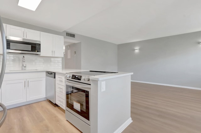296 Fanshaw H, Boca Raton, FL 33434 - kitchen featuring appliances with stainless steel finishes, a sink, light wood-type flooring, and a peninsula