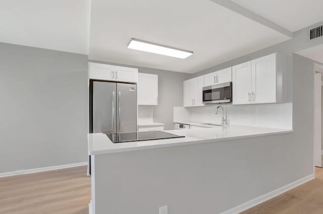 296 Fanshaw H, Boca Raton, FL 33434 - kitchen with stainless steel appliances, a sink, light countertops, and light wood-type flooring
