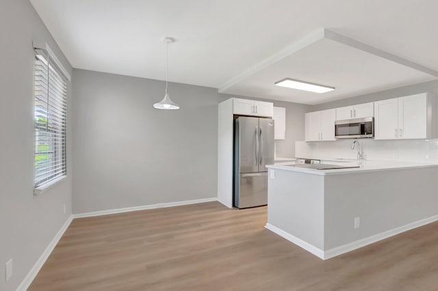296 Fanshaw H, Boca Raton, FL 33434 - kitchen with appliances with stainless steel finishes, a sink, light wood finished floors, white cabinets, and light countertops