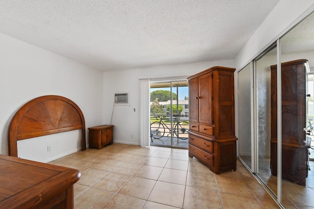 111 Dorchester E Unit 111, West Palm Beach, FL 33417 - foyer with baseboards, a textured ceiling, a wall mounted AC, and light tile patterned flooring