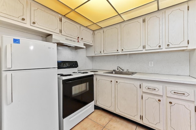 kitchen with range with electric stovetop, a sink, light countertops, freestanding refrigerator, and under cabinet range hood