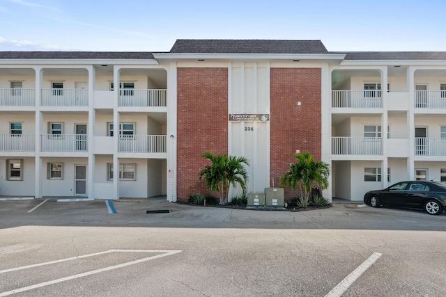 236 Castlewood Dr Unit 301, North Palm Beach, FL 33408 - view of building exterior featuring cooling unit and uncovered parking