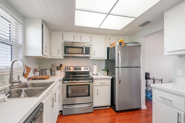 236 Castlewood Dr Unit 301, North Palm Beach, FL 33408 - kitchen with a sink, visible vents, stainless steel appliances, light countertops, and dark wood-style flooring