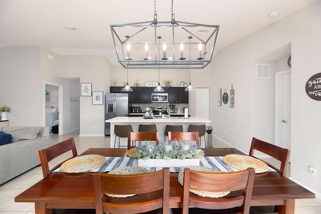 dining room featuring light tile patterned floors, an inviting chandelier, visible vents, and baseboards