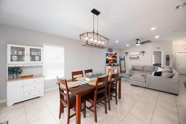 dining space with baseboards, visible vents, light tile patterned floors, and ceiling fan with notable chandelier