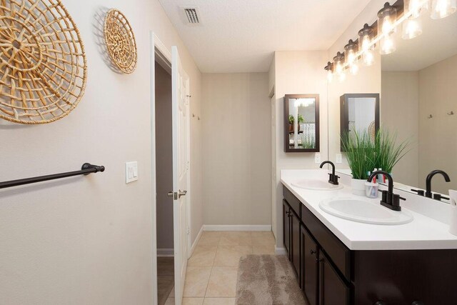 bathroom featuring double vanity, visible vents, tile patterned flooring, and a sink
