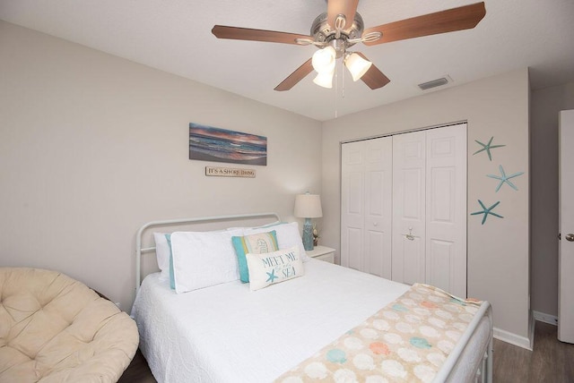 bedroom featuring visible vents, ceiling fan, baseboards, a closet, and dark wood-style flooring