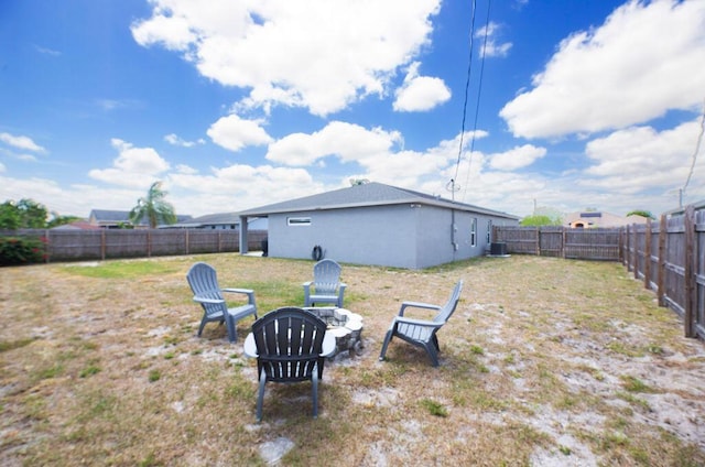 view of yard featuring an outdoor fire pit, a fenced backyard, and central air condition unit