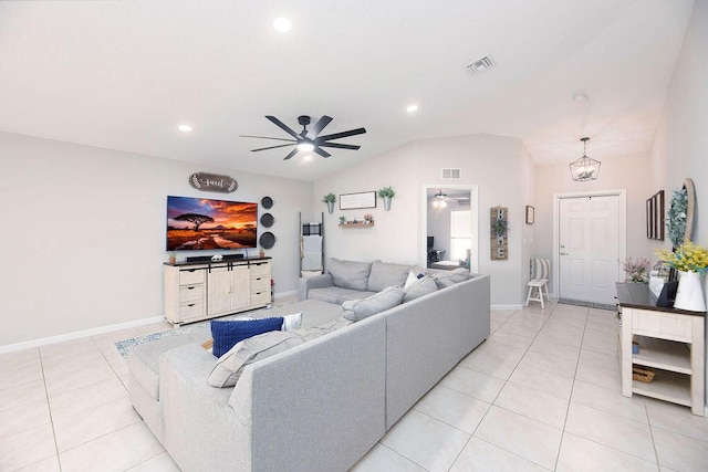 living area with visible vents, light tile patterned floors, ceiling fan with notable chandelier, and lofted ceiling