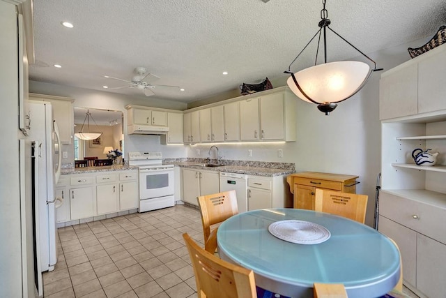 kitchen featuring under cabinet range hood, white appliances, and a textured ceiling