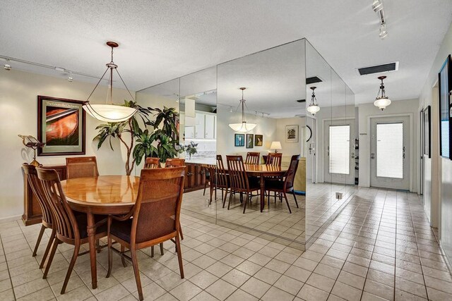 dining area with visible vents, track lighting, and light tile patterned floors