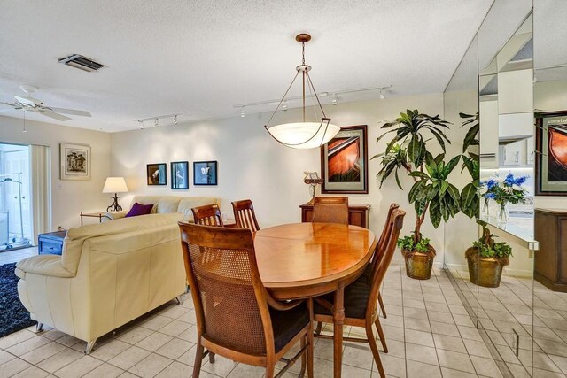 dining room with light tile patterned floors, ceiling fan, rail lighting, and visible vents